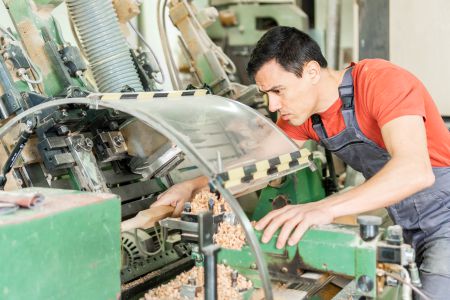 An operative carefully working on an industrial machine.